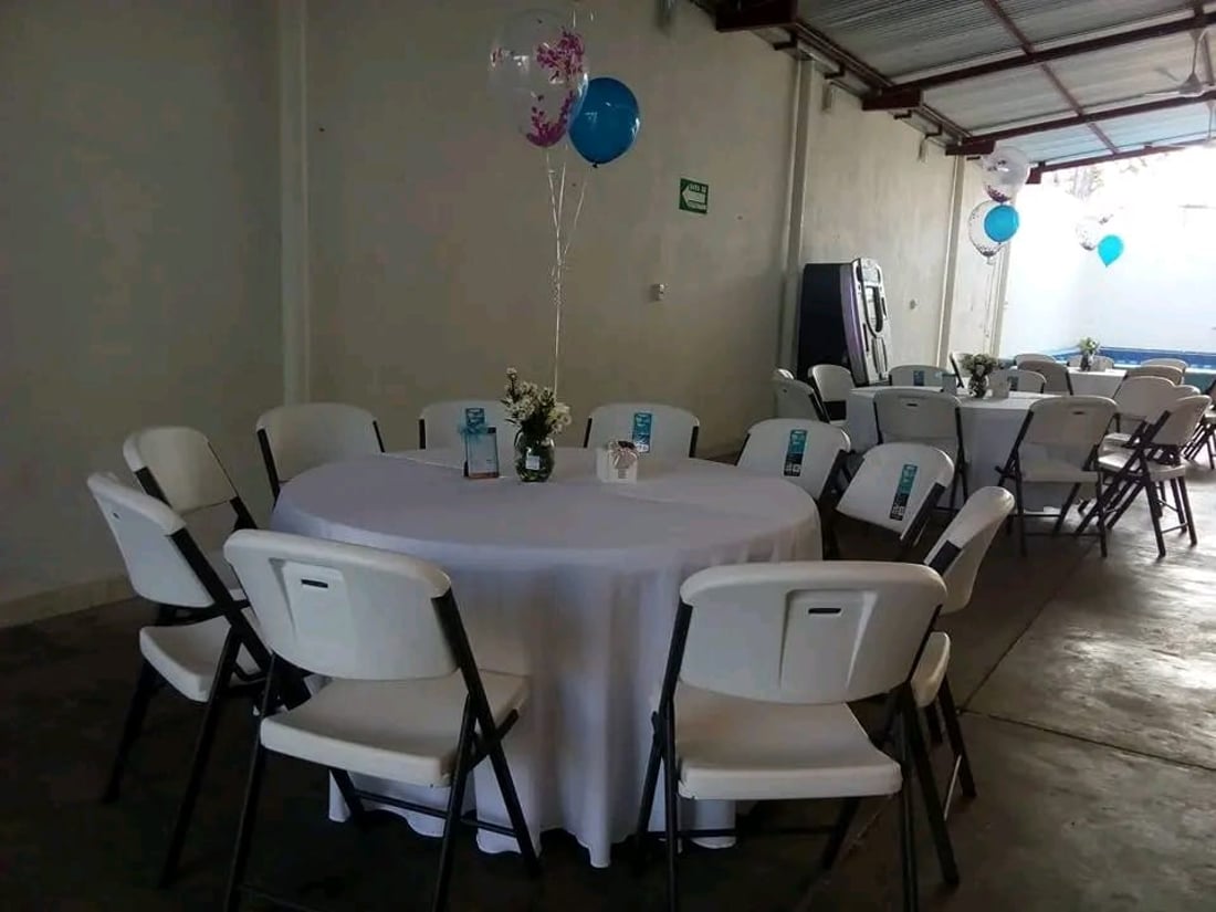 Mesa montada con sillas plegables blancas de renta en Cacahoatán