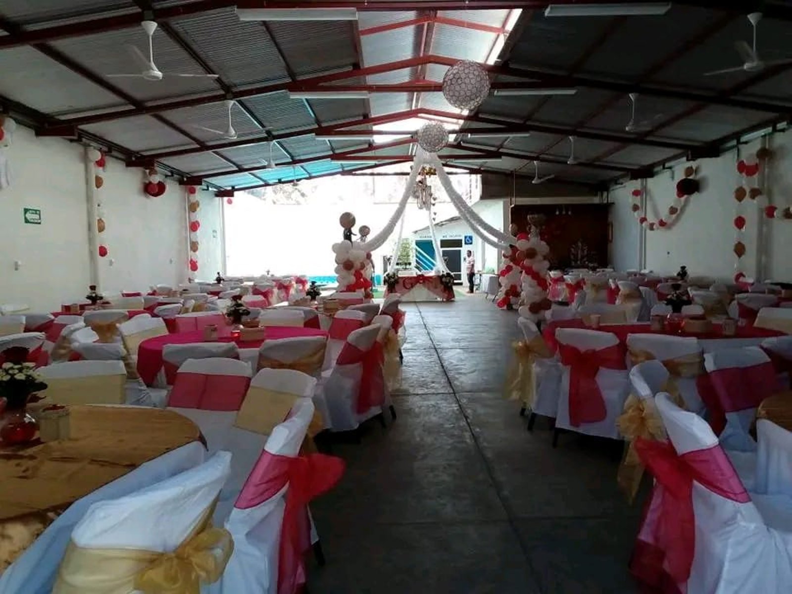 Interior del salón con mesas montadas y la alberca al fondo